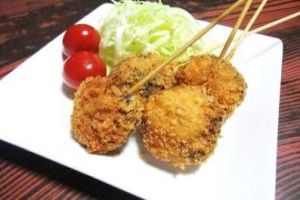 机の上に置かれた角皿に盛られているしいたけの肉詰めフライの写真