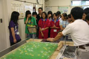 平成21年度の子ども会議にてスーツを着た男性と、女子中学生らが交流している写真