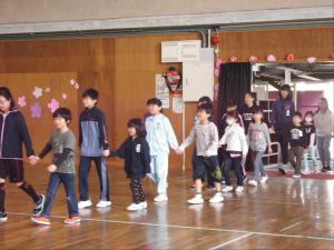 手をつないだ子どもたちが体育館に入ってきている写真