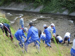 青いジャージを着た生徒たちが地層見学している写真
