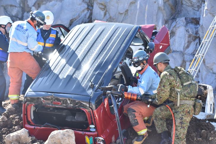 土砂に埋もれた車の中の人を助ける自衛隊、消防、警察の隊員