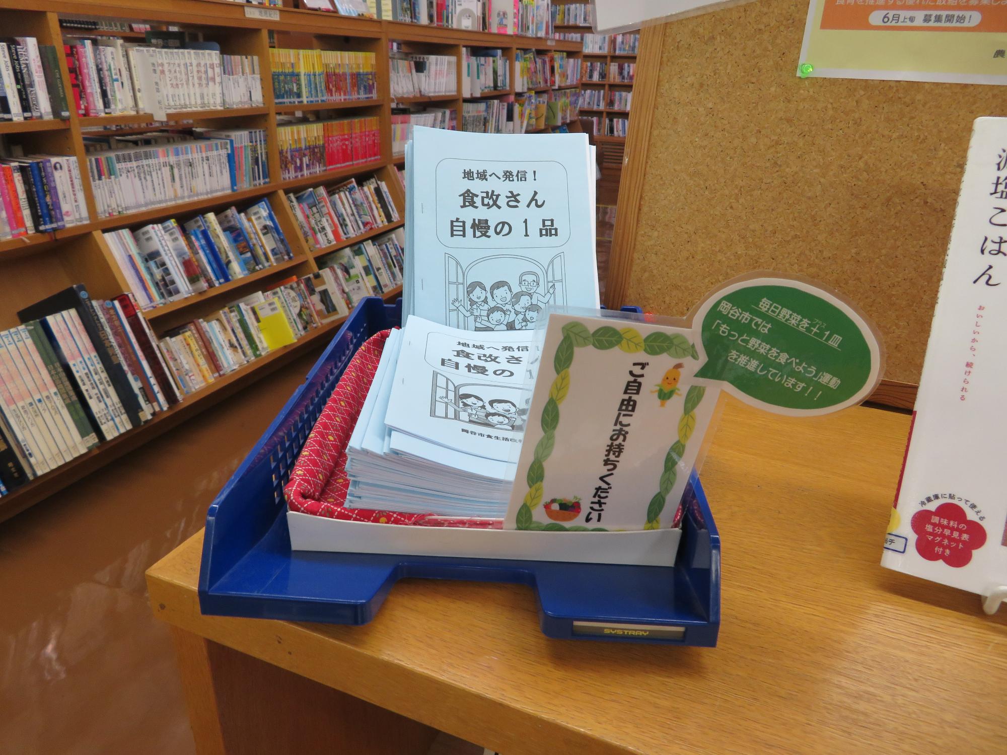 岡谷市食生活改善推進協議会作成の郷土食レシピが棚に置かれている写真