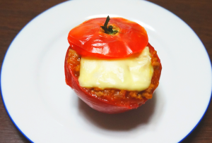 白い皿に映えるトマトカップのなすミートチーズの写真