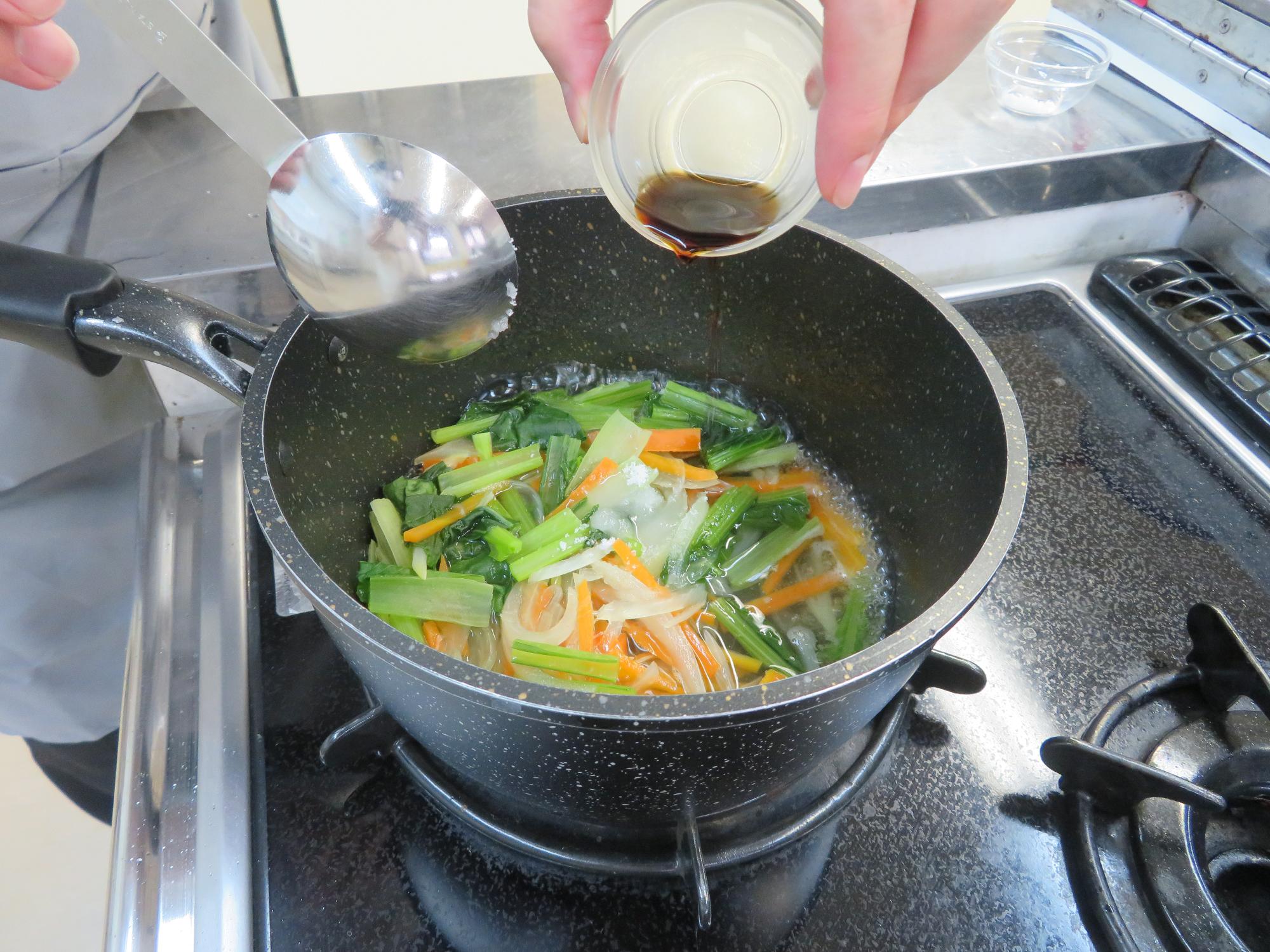 鍋に味付けをしている写真