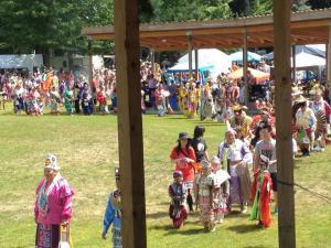 パウワウ祭にて、インディアンの装束を纏った人々が列を成している写真