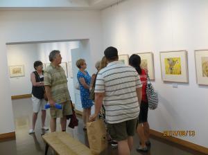 イルフ童画館内にて、壁にかけられた絵画を見物する外国人参加者らの写真