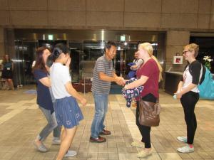 ホストファミリーの日本人家族がマウント・プレザント市の女性と握手している写真
