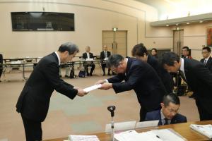 岡谷市基本構想審議会で向かい合ってお辞儀をする男性の写真