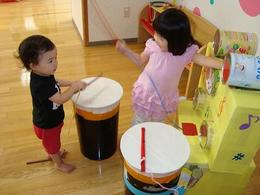 二人の子どもが太鼓を鳴らして遊んでいる写真