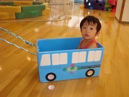 紙で作られたバスに乗っている男の子の写真