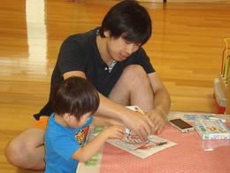 男性と子どもが机で一緒にお絵かきしている写真