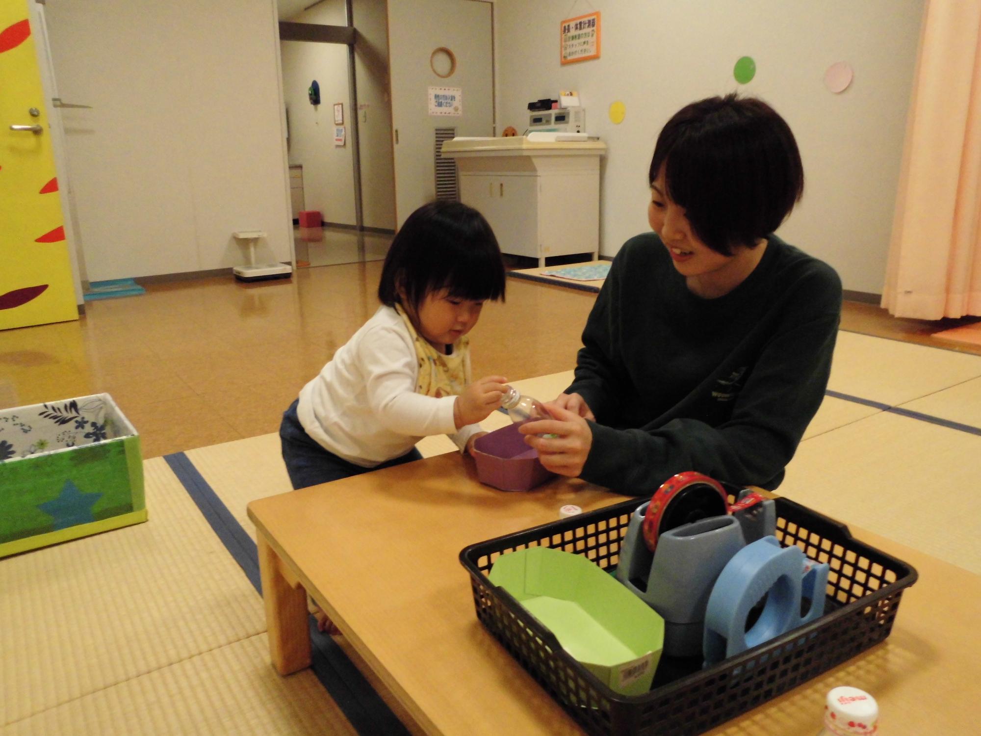 ビーズを瓶にいれるこども