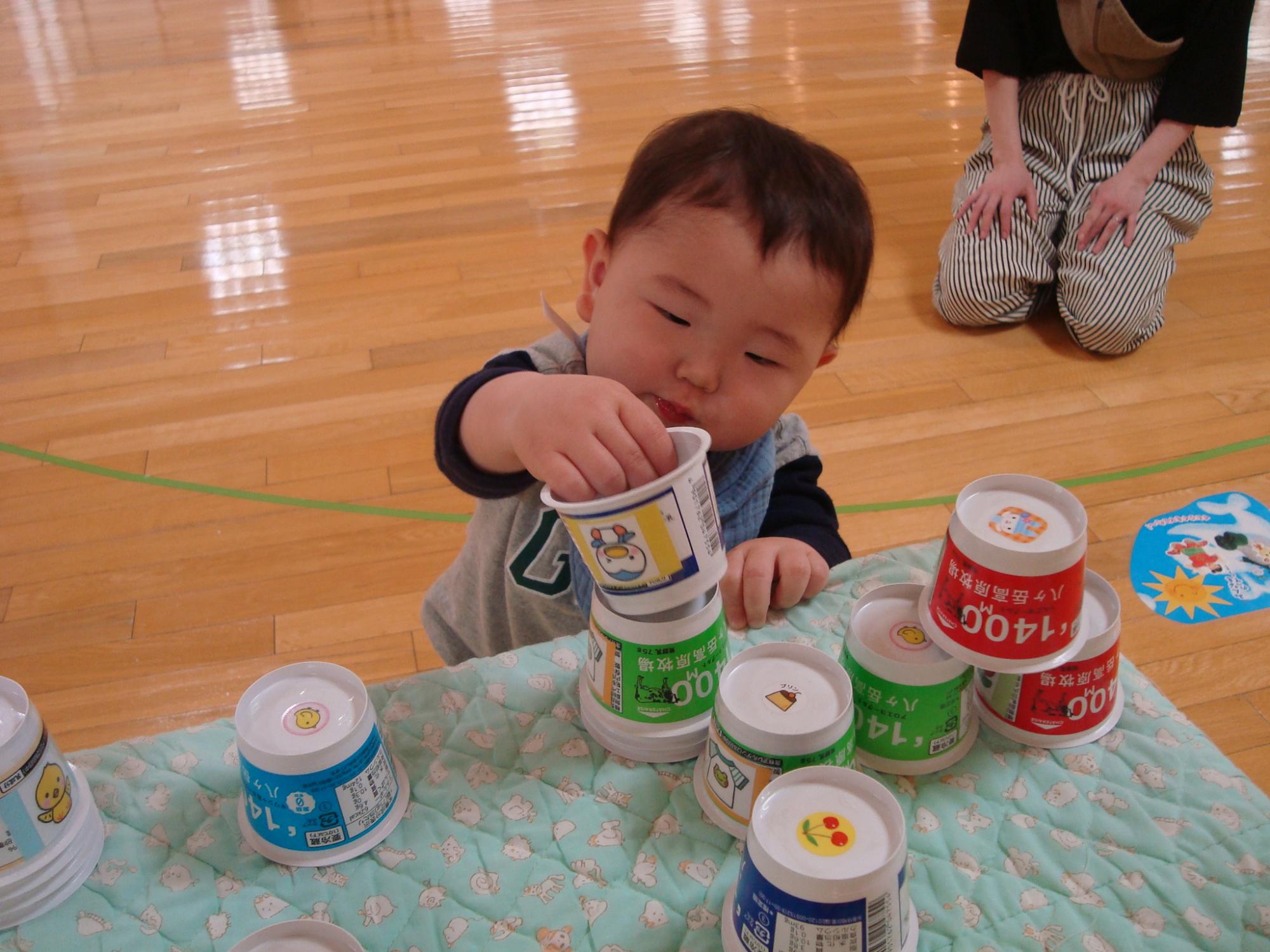 カップで色々遊ぶ子供