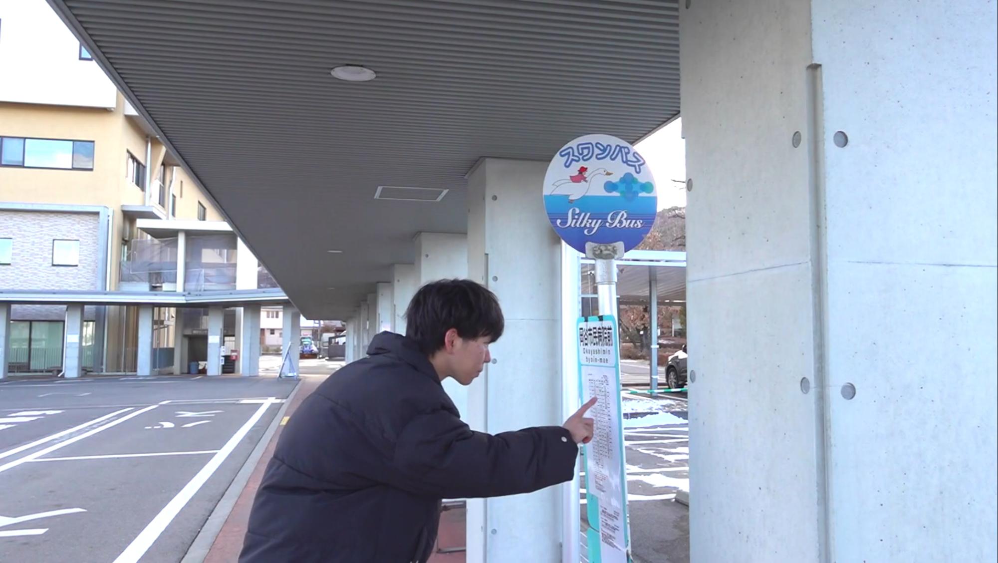 停留所でバスを待つ男性の写真