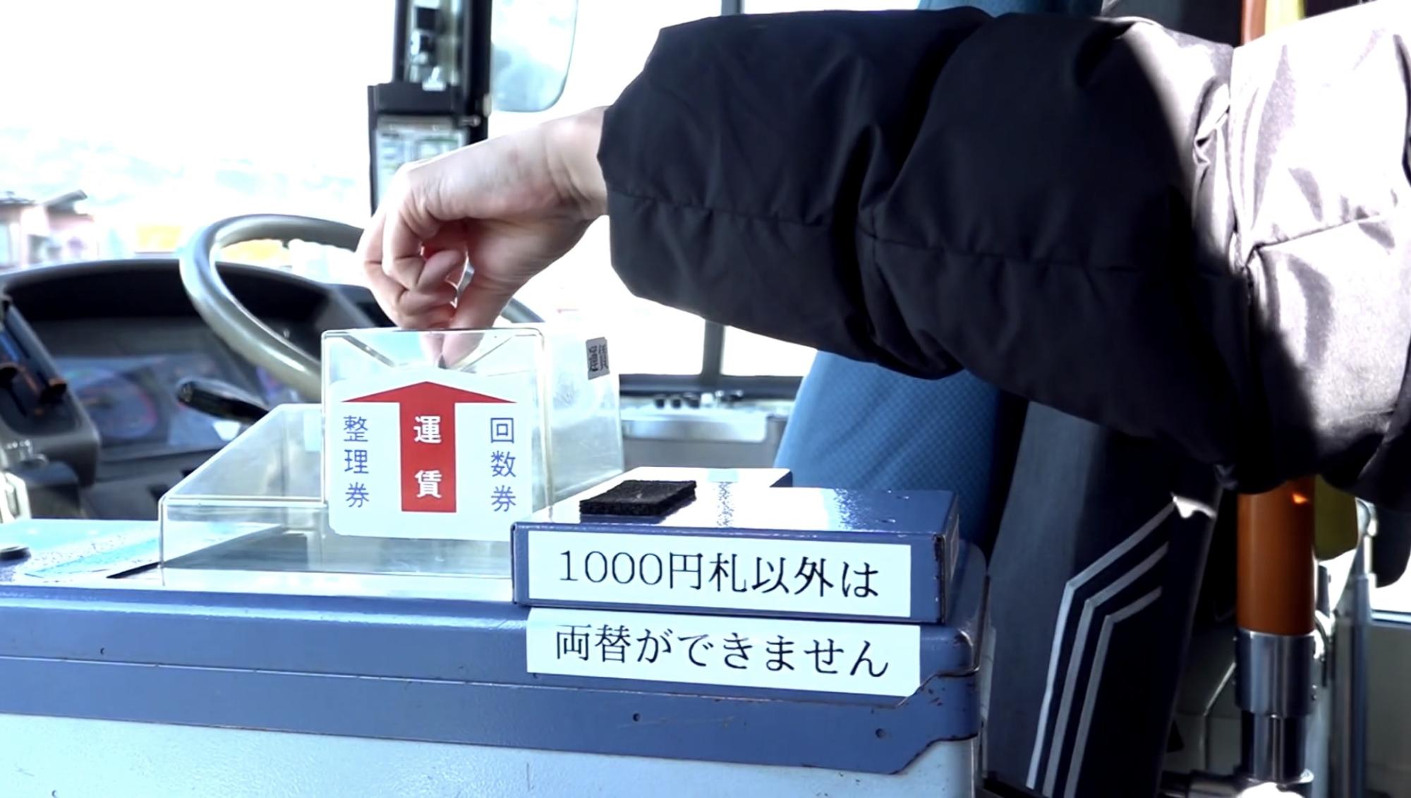 運賃箱へ運賃を投入している写真