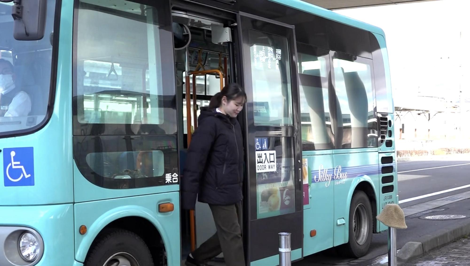 バスから降車する女性の写真