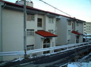 赤い屋根で３階建ての高尾T市営住宅外観写真