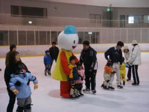 雪だるまの着ぐるみや、大人に後ろから支えられてスケートリンクに立っている子供たちの写真