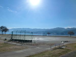 遠くに山並みが見える湖畔広場の写真