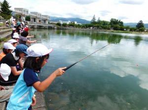 多くの生徒が釣り竿を持って釣りをしている写真