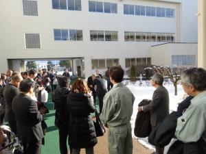 新しくなった校舎を大勢の関係者たちが外から見ている写真