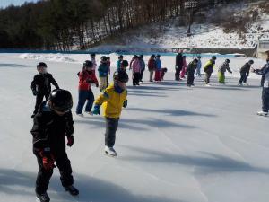 子どもたちが氷の上でスケートをしている写真