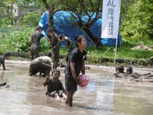 田んぼに入って泥まみれになった生徒たちの写真