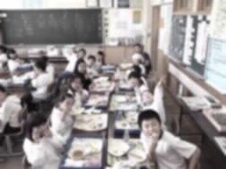 教室でみんなで仲良くたのしそうに給食を食べている写真