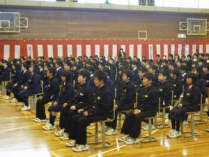 入学式で多数の新一年生が椅子に座って話を聞いている写真