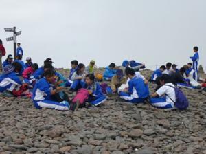 八ヶ岳登山で生徒が斜面で集まって休憩をしている写真