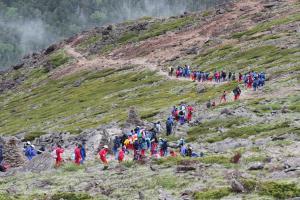 生徒たちが列になって硫黄岳の山道を登っている写真