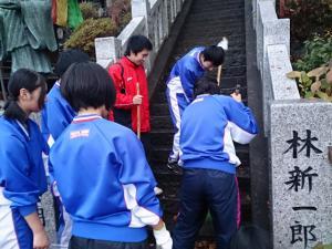 神社の石階段を生徒たちが掃除している写真