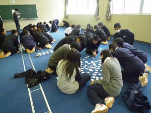 生徒たちが複数のグループに分かれて輪になって百人一首をしている写真