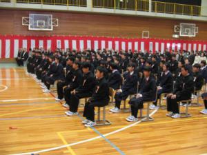 入学式で体育館に多数の生徒が椅子に座って話を聞いている写真