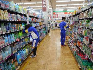 職場体験学習で生徒がスーパーマーケットの棚の商品を調べている写真