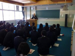 教室内で生徒たちが正座して薬師寺の和尚さんのお話を聞いている写真