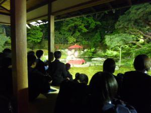生徒たちがお寺の建物の中から庭を眺めている写真