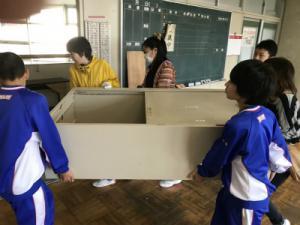 新教室棟への引越しでロッカーを四人の生徒が持って運んでいる写真