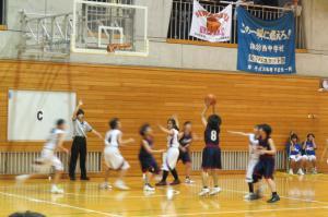 体育館でバスケットボールの試合をする複数の生徒たちの写真