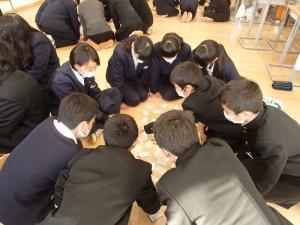 百人一首大会で複数のグループに分かれた生徒たちが輪になって座って百人一首をしている写真