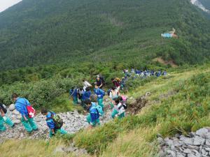 たくさんの生徒が石の道を通って登山をしている写真