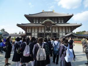 生徒たちが集まってお寺の外観を見ている写真