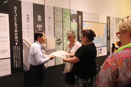 蚕糸博物館でシルクを手に取り説明を聞く
